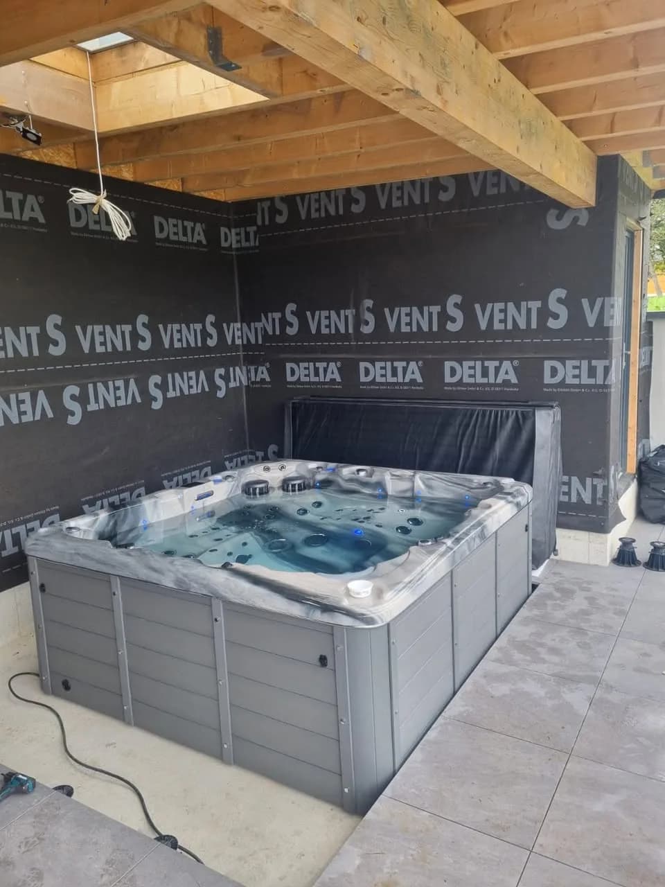 Installation d'un spa Sydney à Magstatt-le-Bas, sous un abri en bois, cuve Odyssey