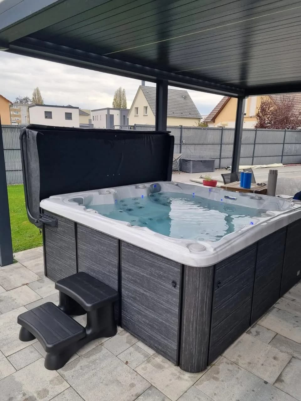 Installation d'un spa Sydney, sous une pergola en aluminium, marchepied