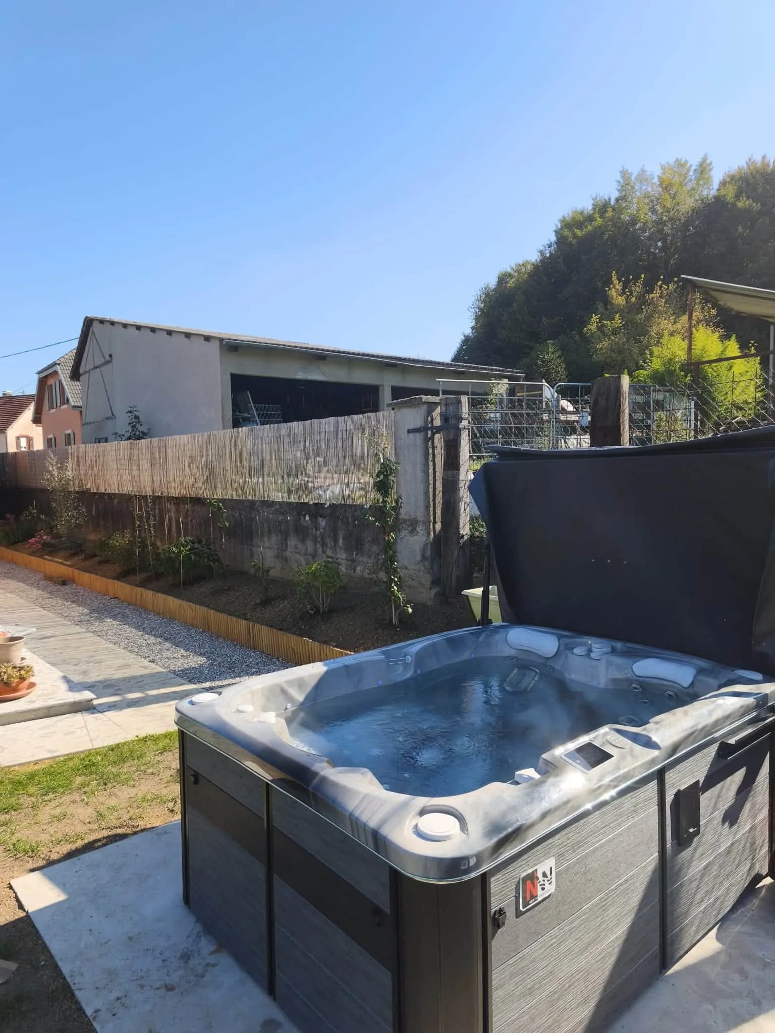 Installation d'un spa Tønsberg à Aspach, sur une dalle en bord de jardin, cuve grise marbrée