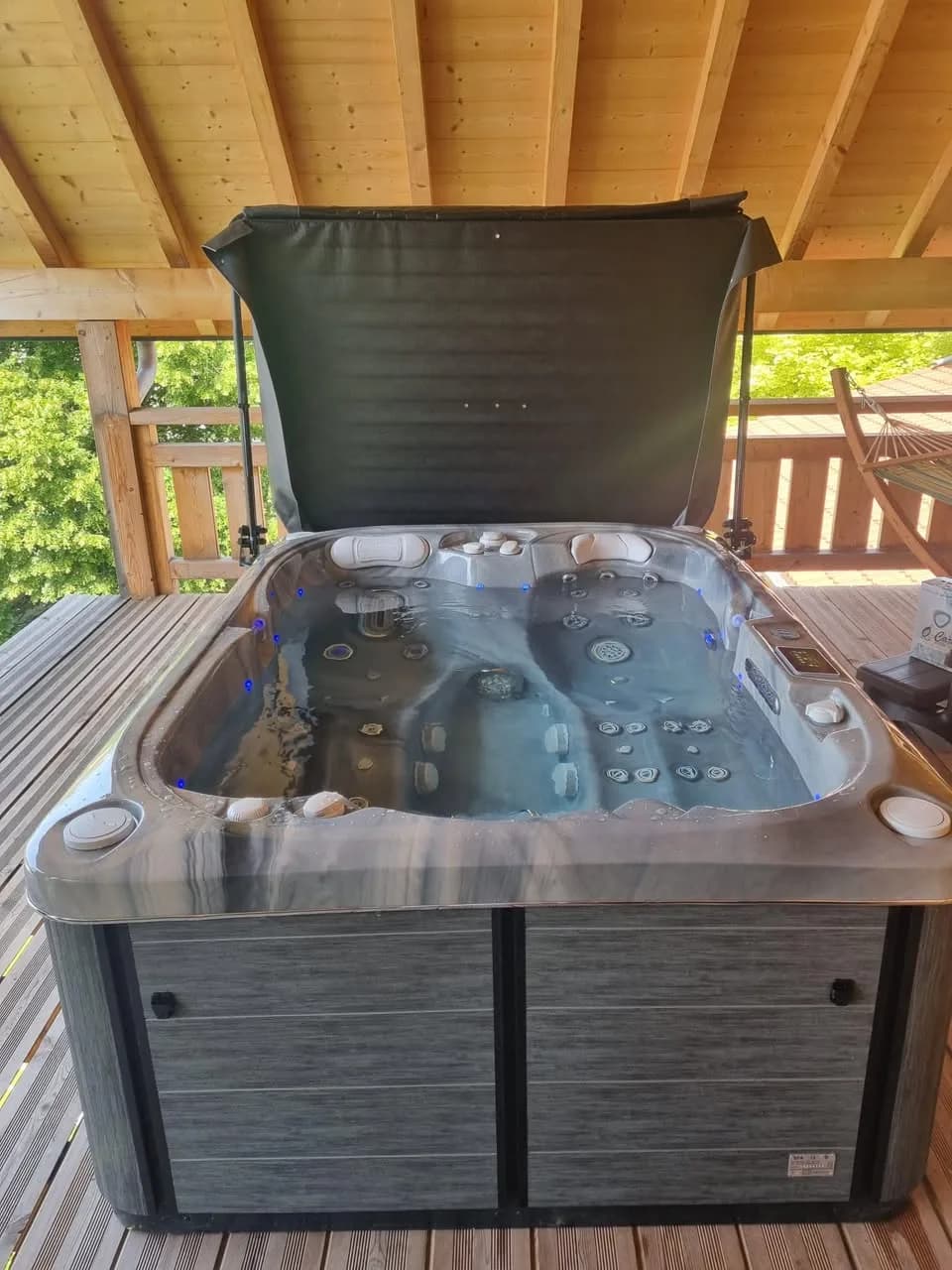 Installation d'un spa Tønsberg à Chaffois, sur une terrasse couverte d'un auvent en bois