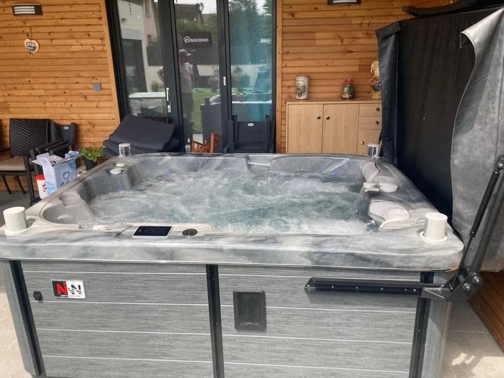 Installation d'un spa Tønsberg à Ensisheim, sous une terrasse couverte habillée de bois