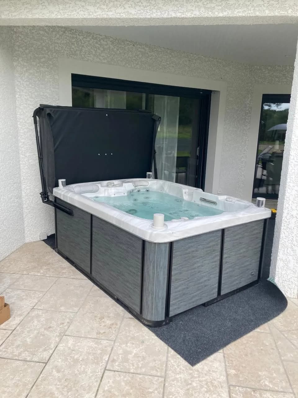Installation d'un spa Tønsberg Full option à La Neuville Saint-Rémy, sur une terrasse dallée devant la maison