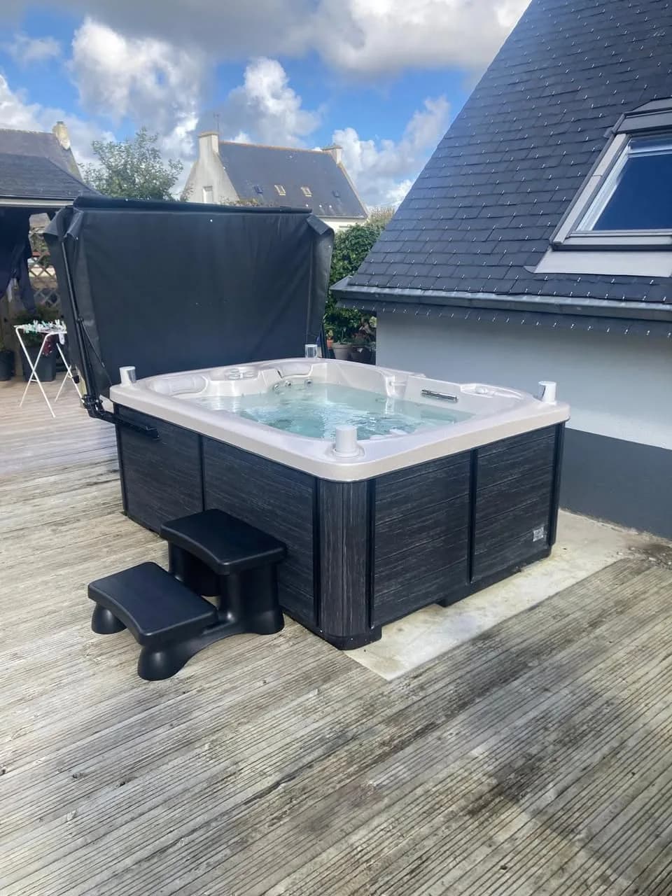 Installation d'un spa Tønsberg Full option à Mizilac, sur une terrasse en bois, avec marchepied