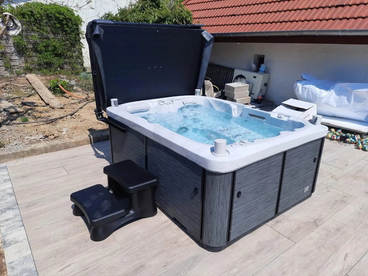 Installation d'un spa Tønsberg Full option à Traubach-le-Bas, sur une terrasse dallée, marchepied et lève-couverture