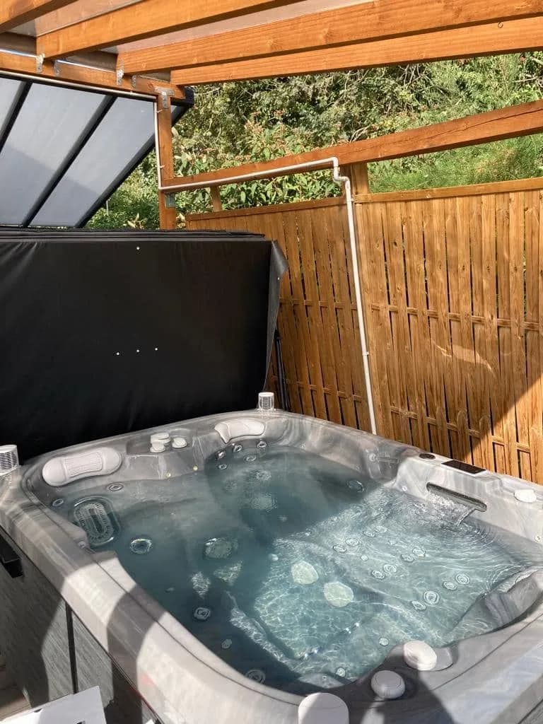 Installation d'un spa Tønsberg à Hochfelden, sous une pergola devant une palissade