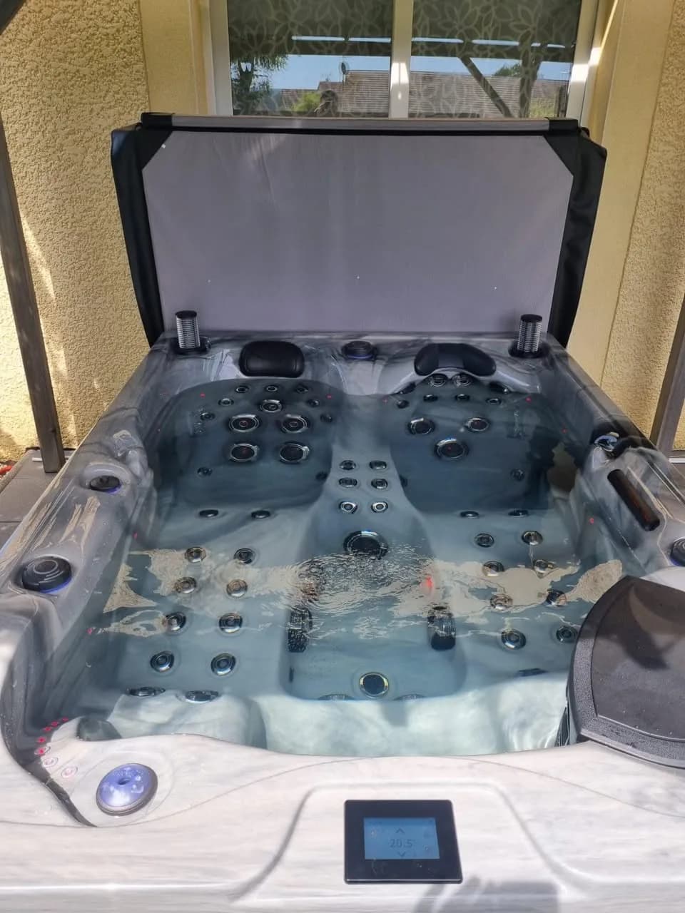 Installation d'un spa Topaz à Briaucourt, sous un abri, couverture relevée