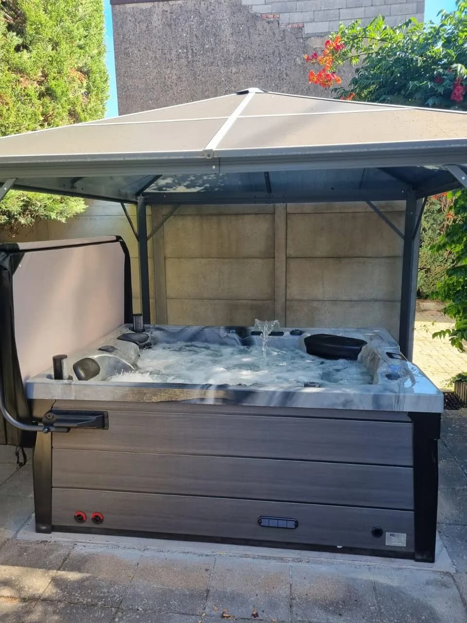 Installation d'un spa Topaz à Cernay, sous une tonnelle, lève-couverture
