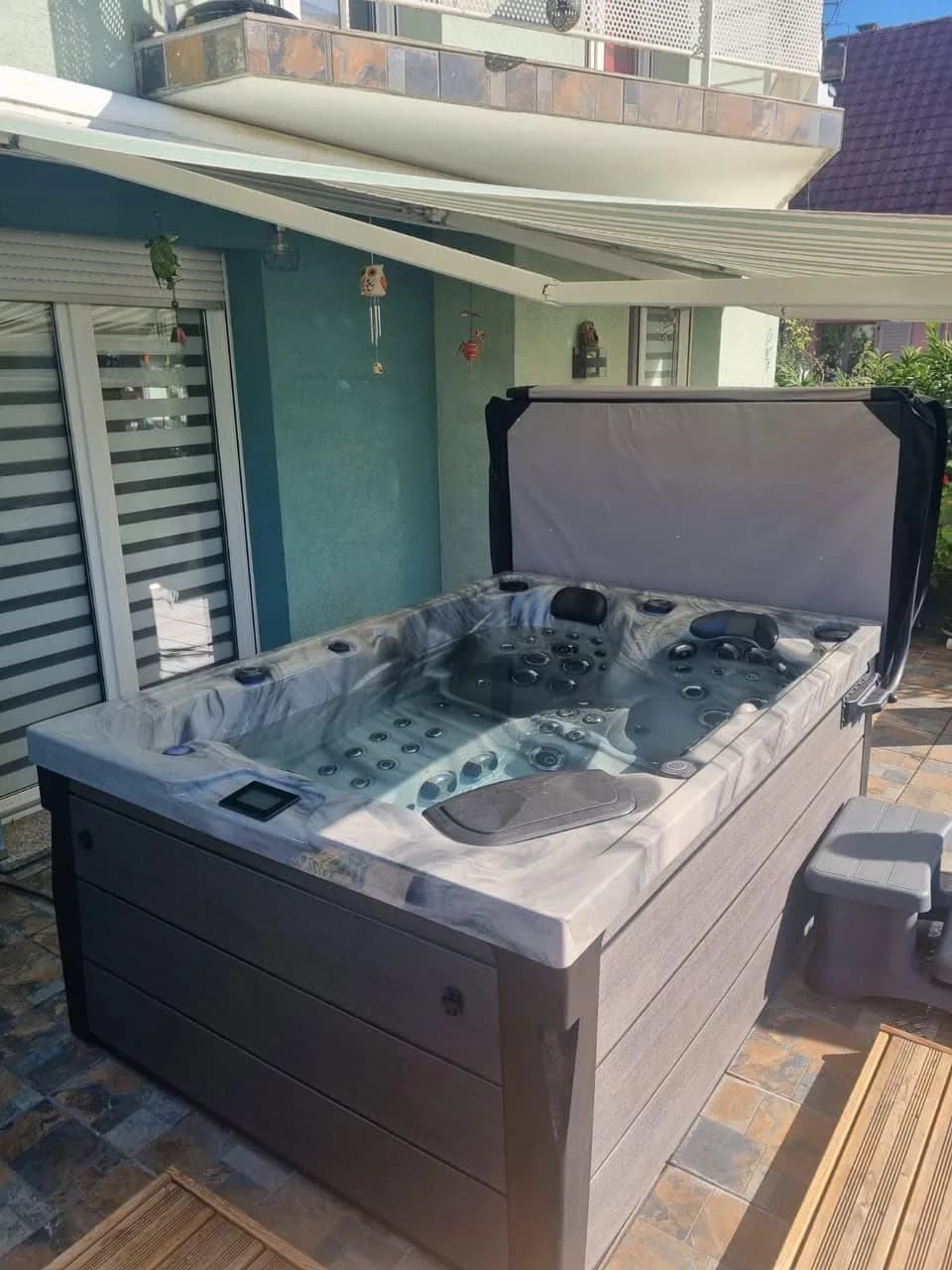 Installation d'un spa Topaz à Colmar, sur une terrasse en bois sous un store