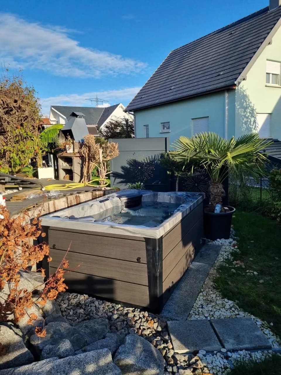 Installation d'un spa Topaz Full option à Niffer, dans un jardin paysager, palmiers