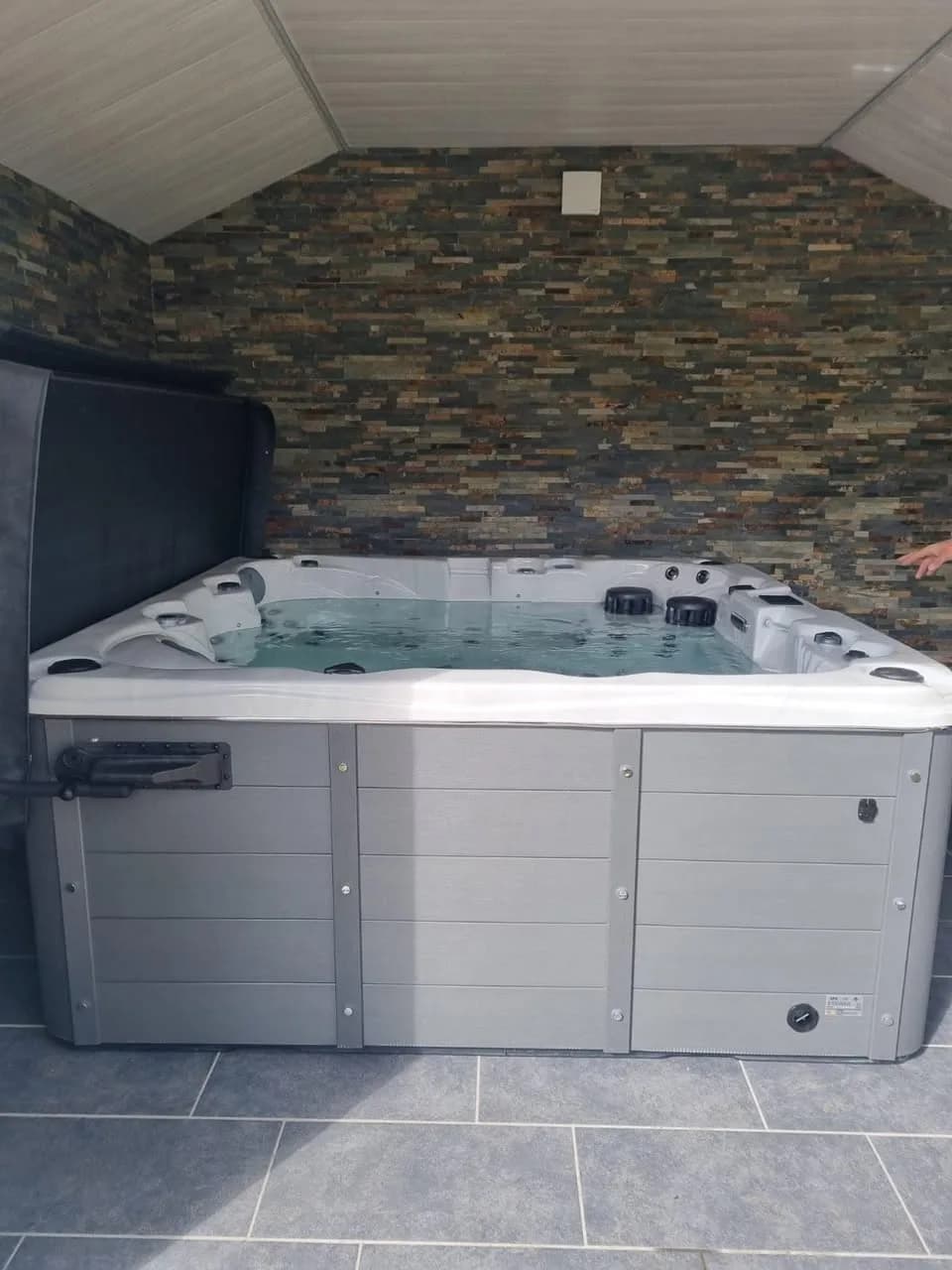 Installation d'un spa Toronto à Bissert, contre un mur en parement de pierre