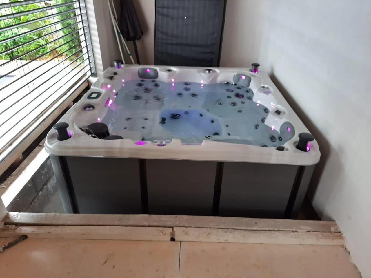 Installation d'un spa Toronto à Dessenheim, dans une pièce, entouré d'un plancher, éclairage LED