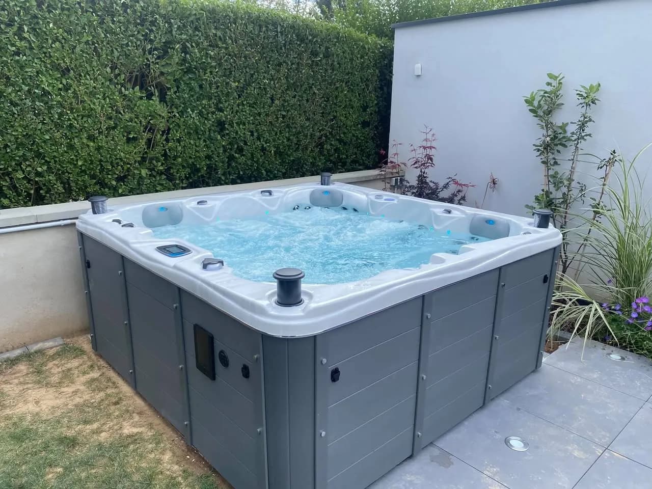 Installation d'un spa Toronto Full option à Griesheim-sur-Souffel, sur une dalle carrelée devant une haie