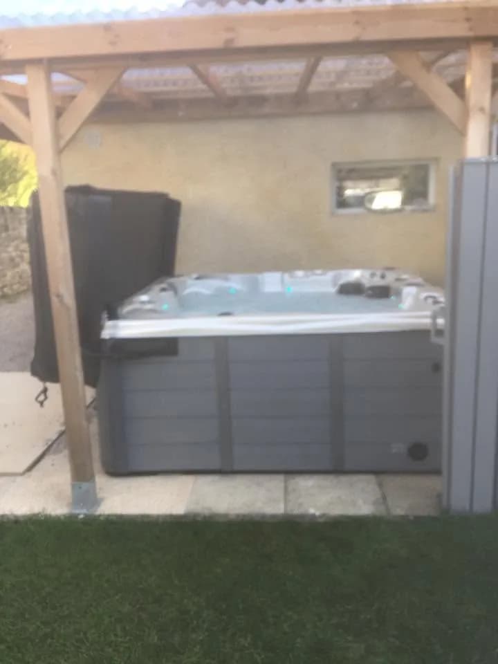 Installation d'un spa Toronto Full option à Oltingue, sous une pergola en bois au bord du gazon