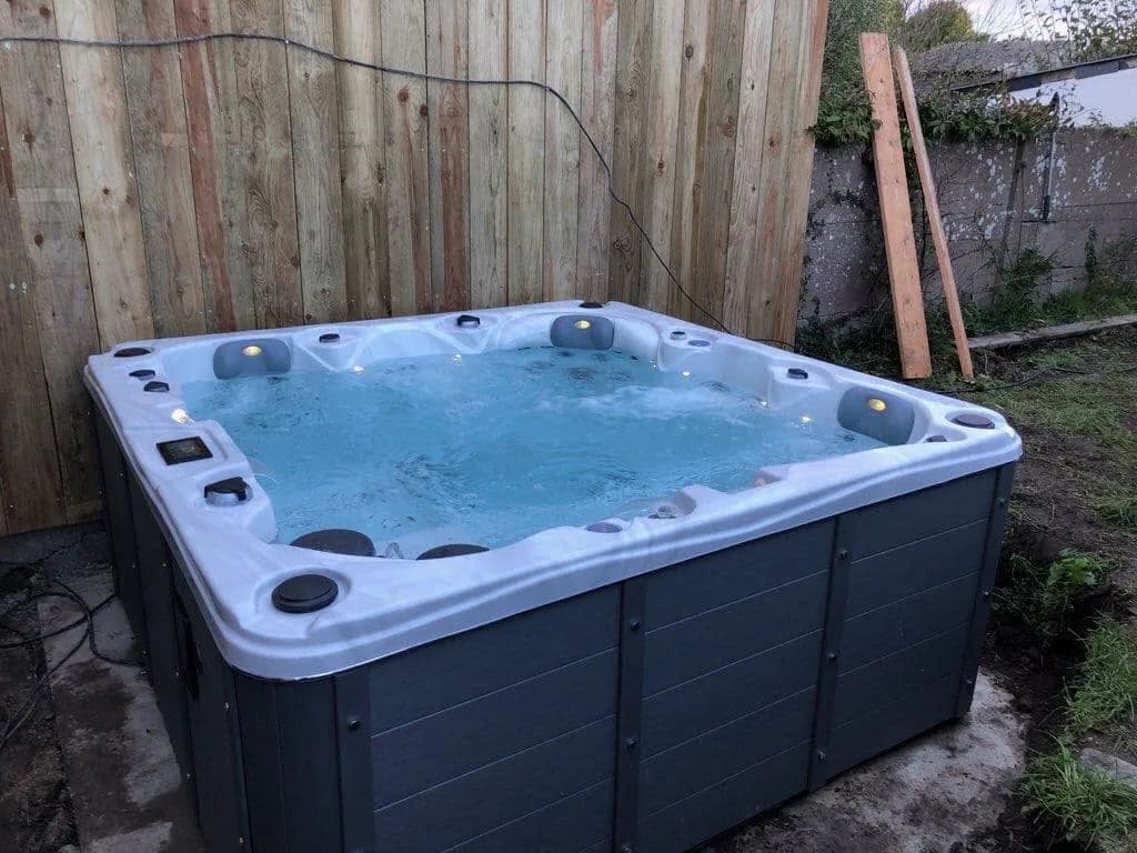 Installation d'un spa Toronto à Guérande, devant une palissade en bois