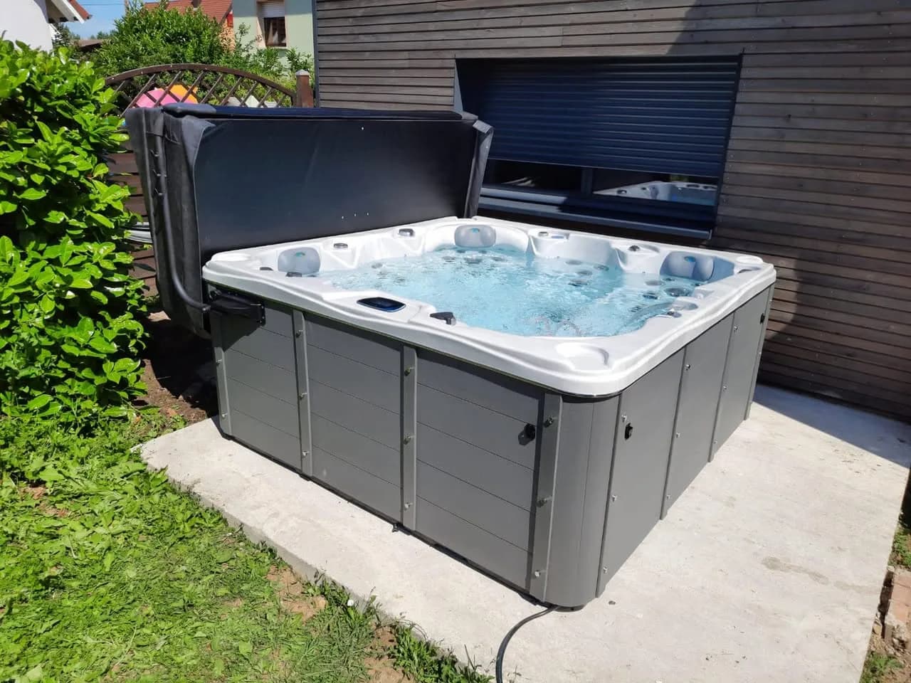Installation d'un spa Toronto à Réguisheim, sur une dalle béton devant un bardage en bois