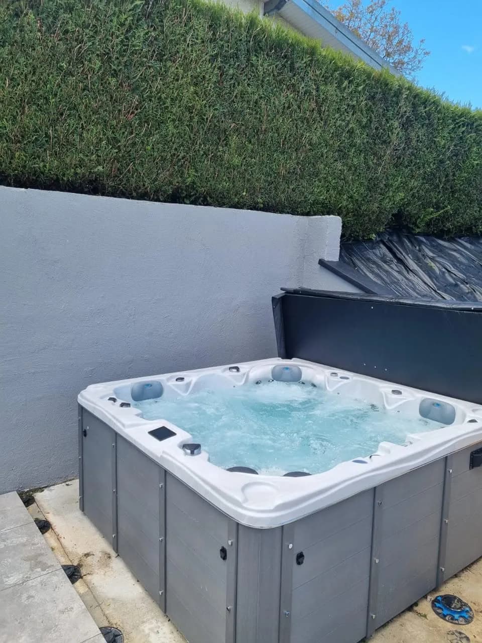 Installation d'un spa Toronto à Seloncourt, sur une dalle au pied d'une haie