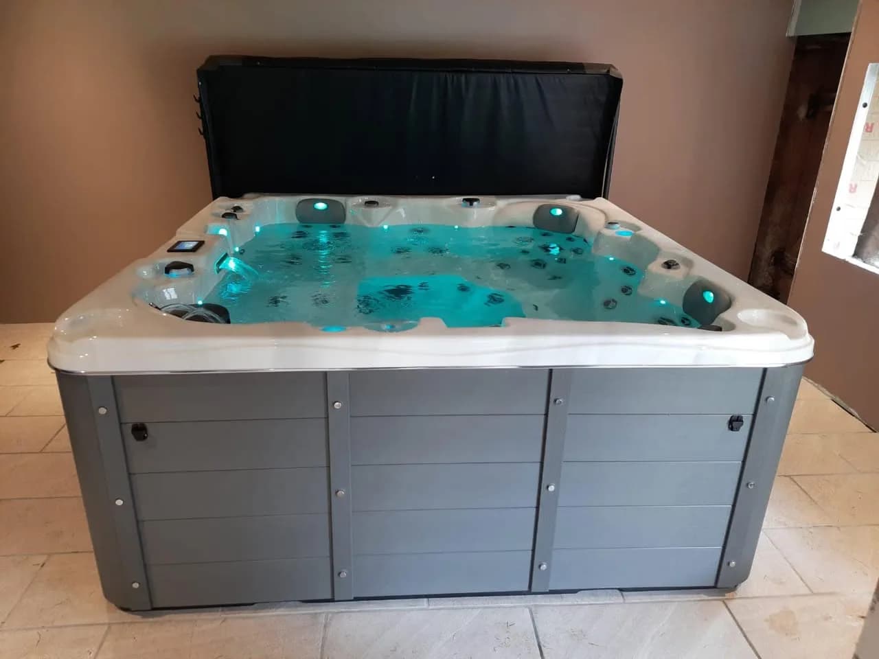 Installation d'un spa Toronto à Tendon, en intérieur sur un sol carrelé, éclairage LED