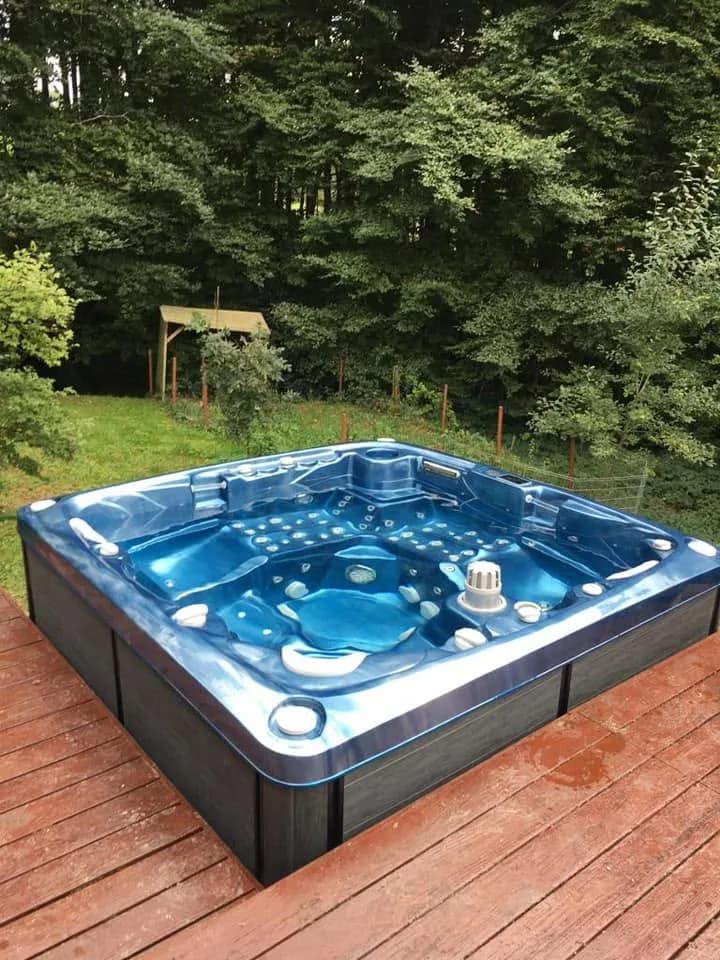 Installation d'un spa Tørrvika à Arbusigny, sur une terrasse en bois en lisière de forêt