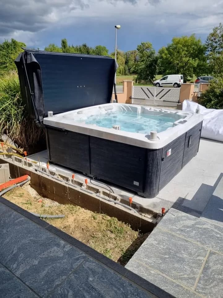 Installation d'un spa Tørrvika à Aspach-le-Bas, sur une dalle, lève-couverture