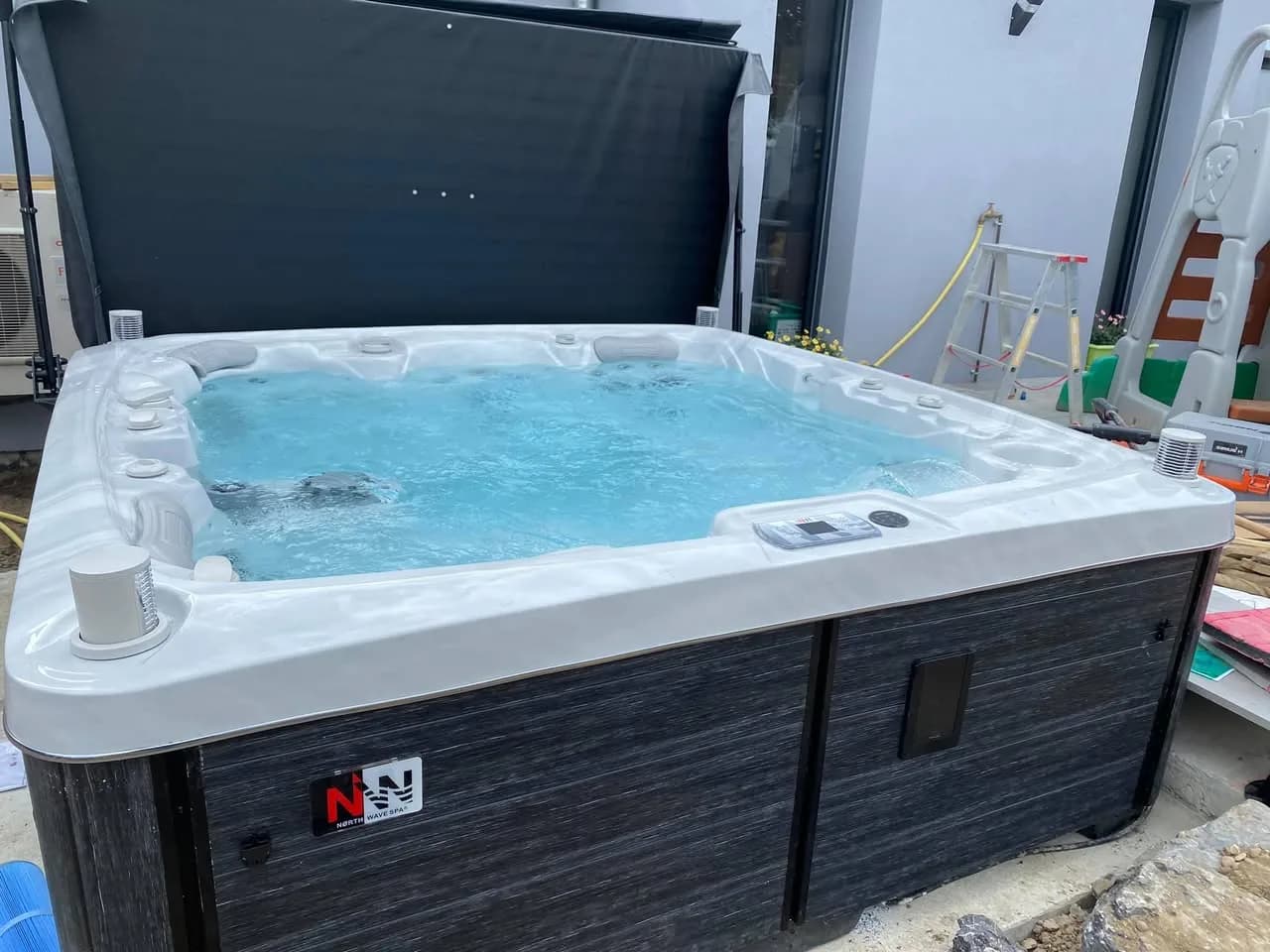 Installation d'un spa Tørrvika Full option à Gambsheim, contre la maison, avec lève-couverture