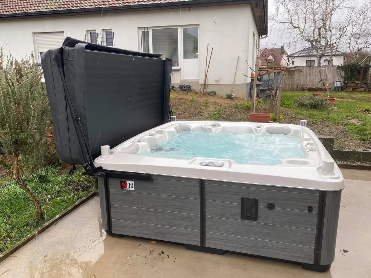 Installation d'un spa Tørrvika, sur une dalle dans le jardin, avec lève-couverture