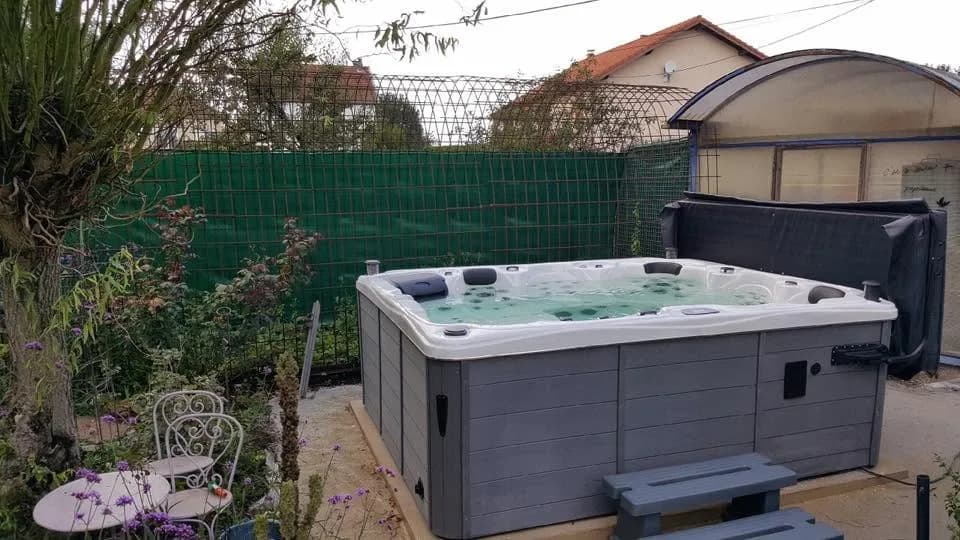 Installation d'un spa Trevi Full option en Moselle, sur du gravier devant une palissade