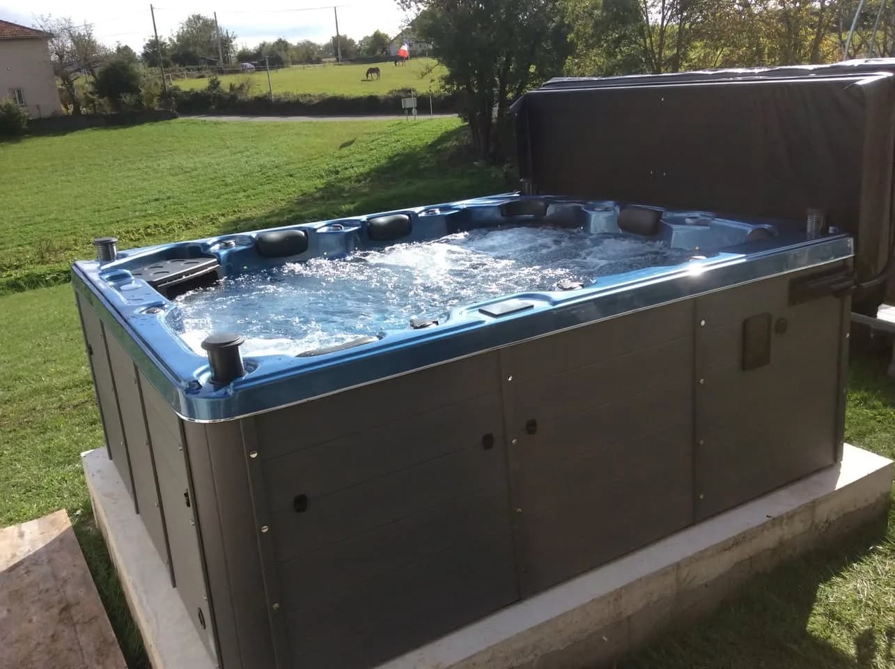 Installation d'un spa Trevi Full option à Roche, sur une dalle au milieu d'une pelouse