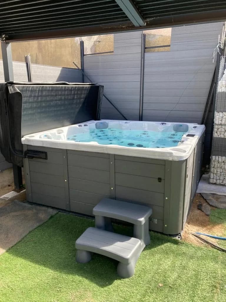 Installation d'un spa Vancouver à Agde, sur un gazon synthétique, marchepied