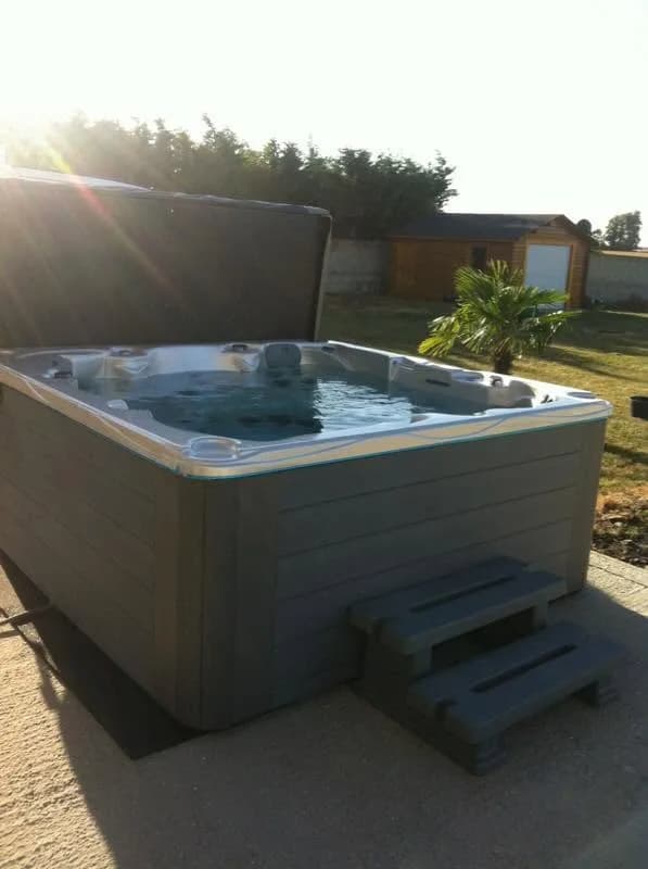 Installation d'un spa Vancouver à Allainville, dans un jardin, marchepied