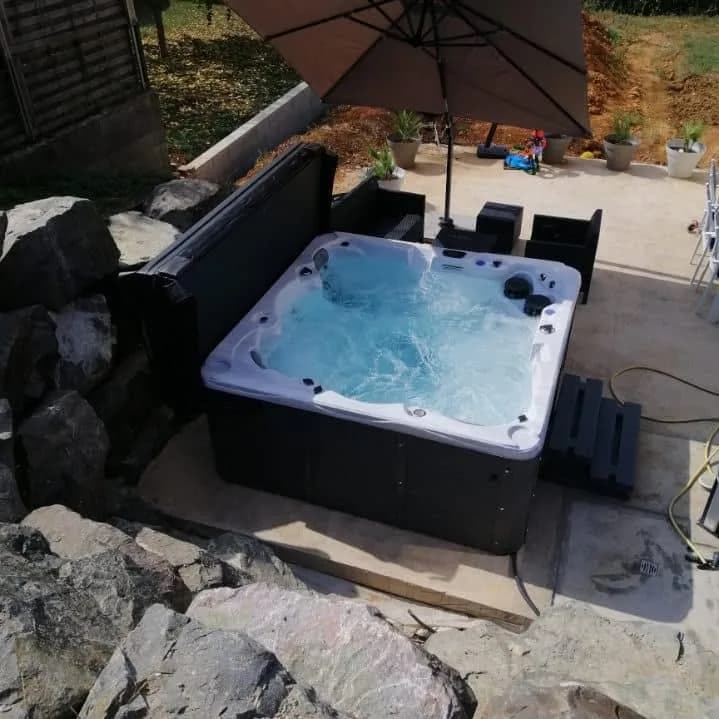 Installation d'un spa Vancouver à Andelnans, sur une terrasse entourée d'une rocaille