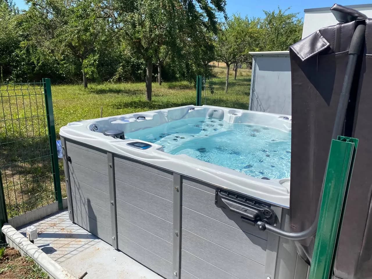 Installation d'un spa Vancouver à Balbronn, dans un jardin, avec lève-couverture