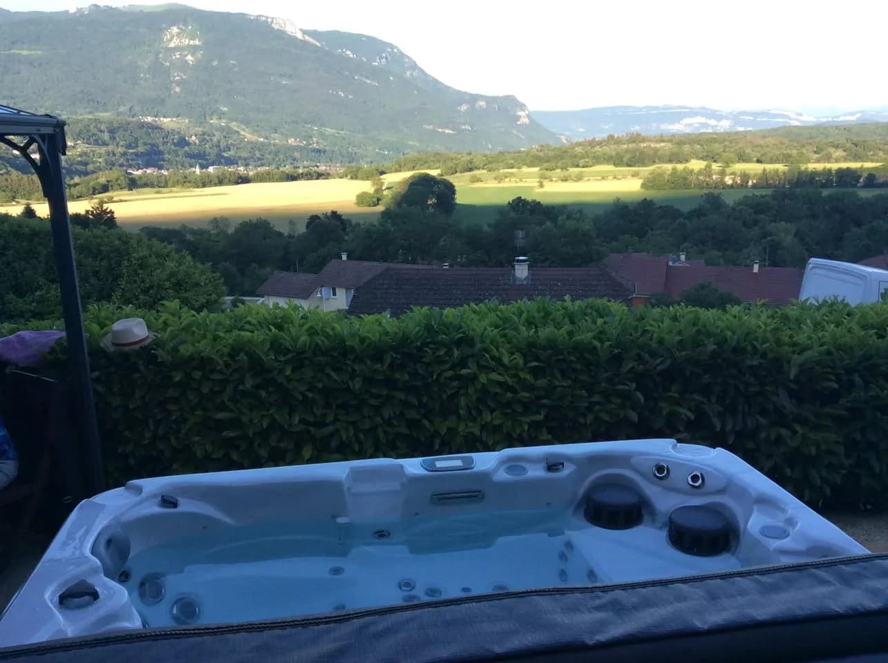 Installation d'un spa Vancouver à Belmont-Luthézieu, face à la vallée, derrière une haie