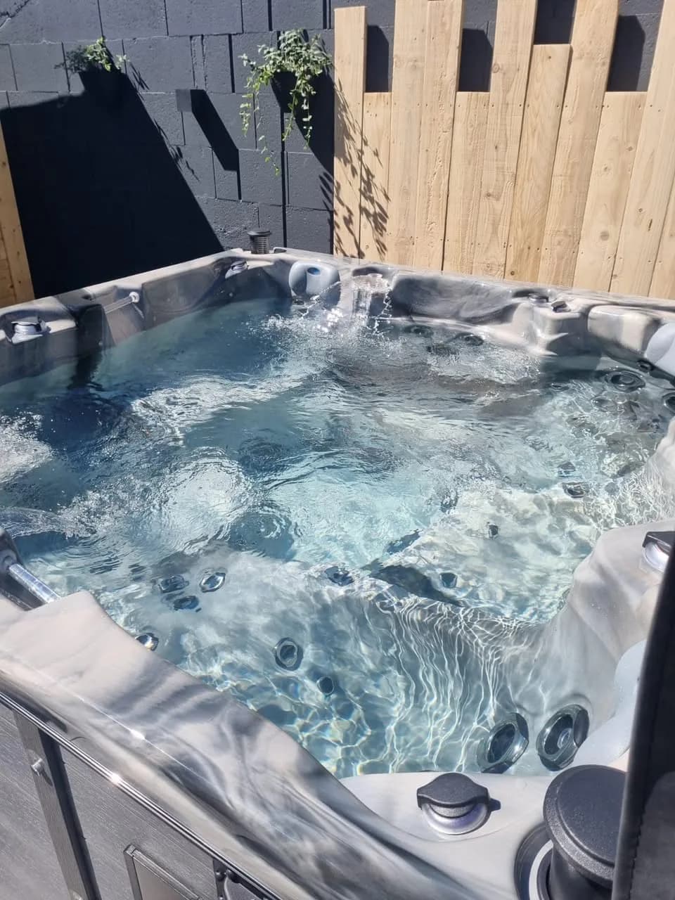 Installation d'un spa Vancouver à Buhl, devant une palissade en bois