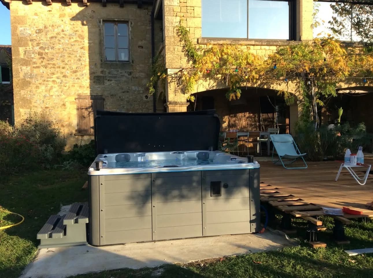 Installation d'un spa Vancouver à Cénac-et-Saint-Julien, dans un jardin au pied d'une maison en pierre