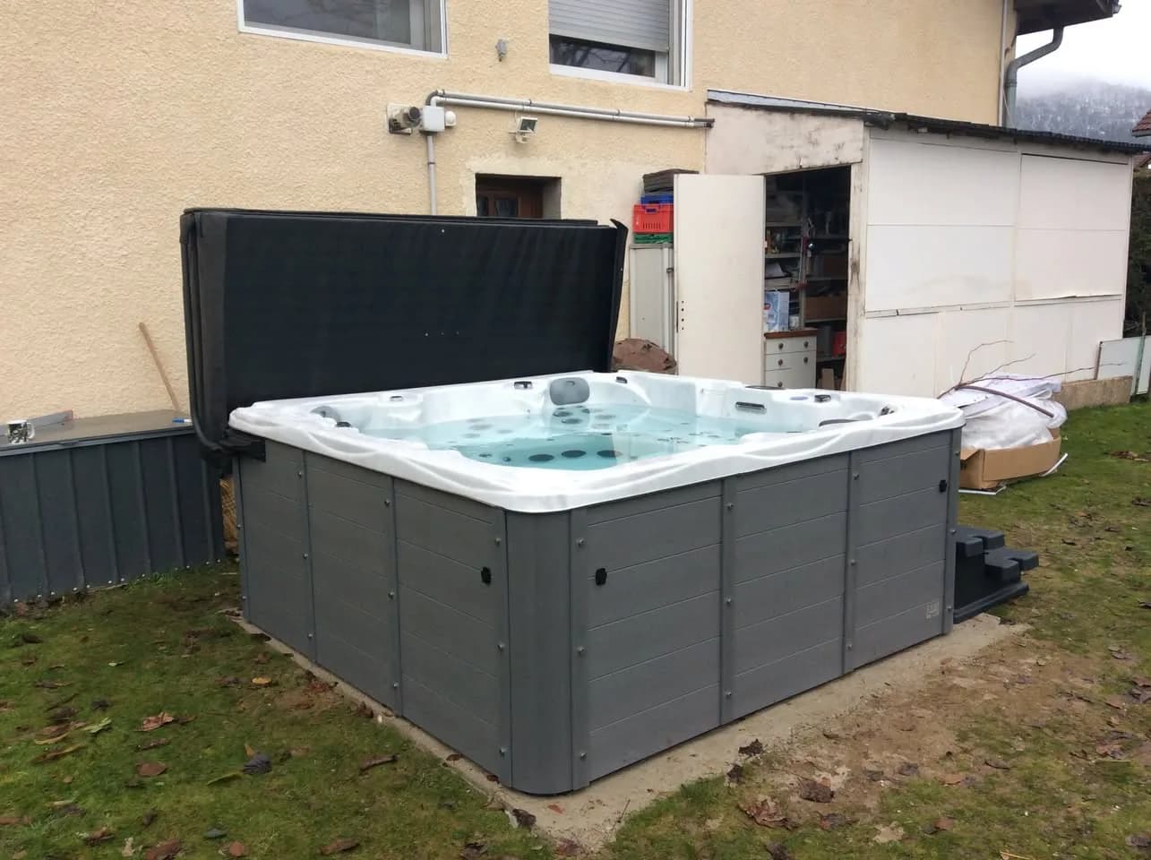 Installation d'un spa Vancouver à Cessy, sur la pelouse contre la maison, lève-couverture