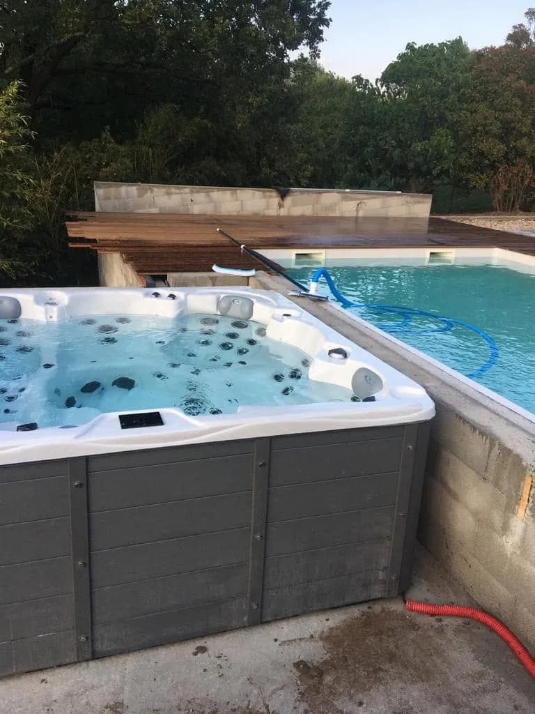 Installation d'un spa Vancouver à Châteauneuf-le-Rouge, au bord d'une piscine, muret en construction