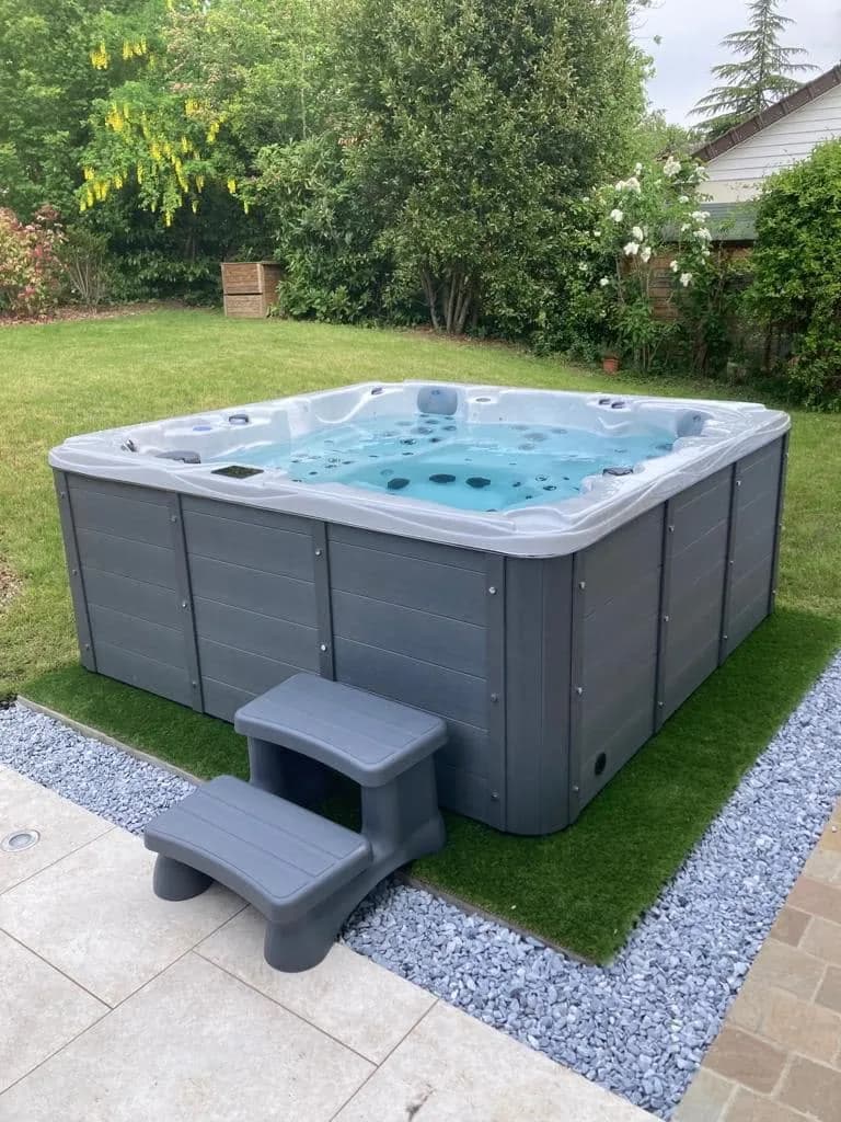 Installation d'un spa Vancouver à Chevreuse, sur un gazon synthétique bordé de gravier