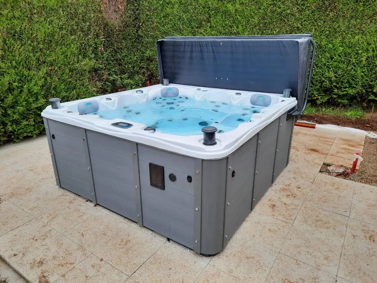 Installation d'un spa Vancouver à Dabo, sur une dalle devant une haie