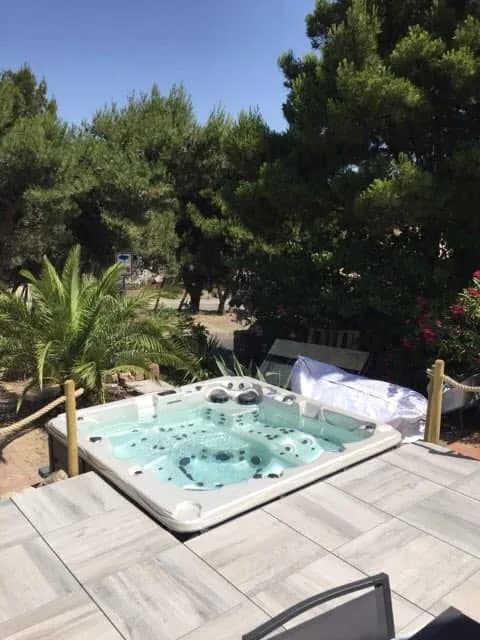 Installation d'un spa Vancouver dans l'Aude, en contrebas d'une terrasse entouré d'un dallage