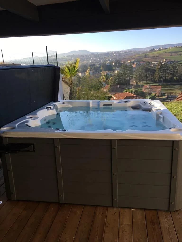 Installation d'un spa Vancouver dans la Loire, sur une terrasse en bois avec vue sur les collines