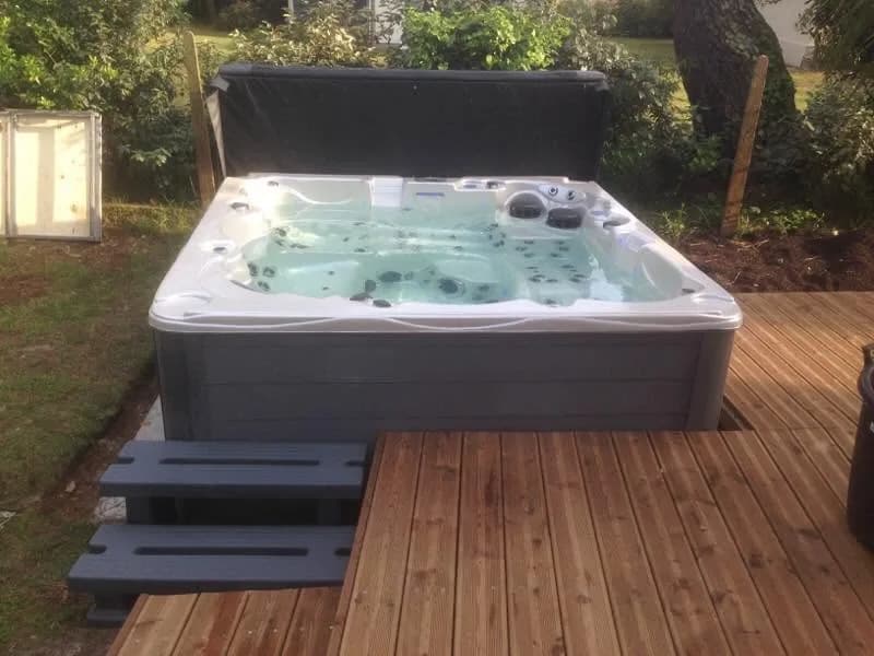 Installation d'un spa Vancouver dans les Landes, sur une terrasse en bois, marchepied