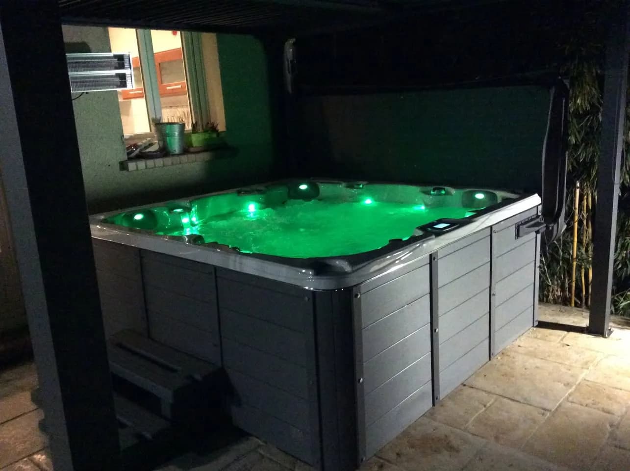 Installation d'un spa Vancouver dans les Yvelines, sous un abri, éclairage LED allumé de nuit