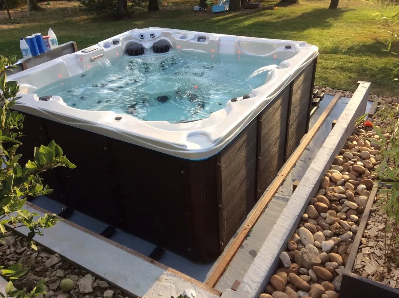 Installation d'un spa Vancouver à Échalas, sur une dalle béton bordée de galets