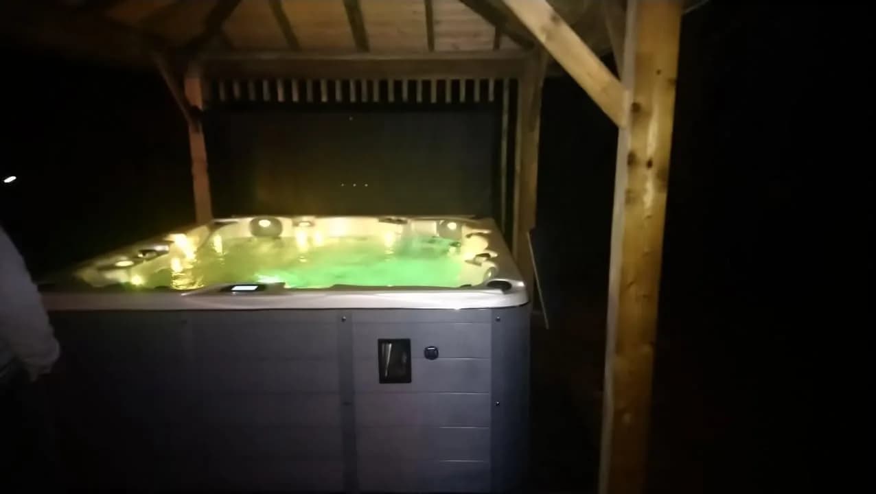 Installation d'un spa Vancouver en Seine-Maritime, sous un abri en bois, de nuit