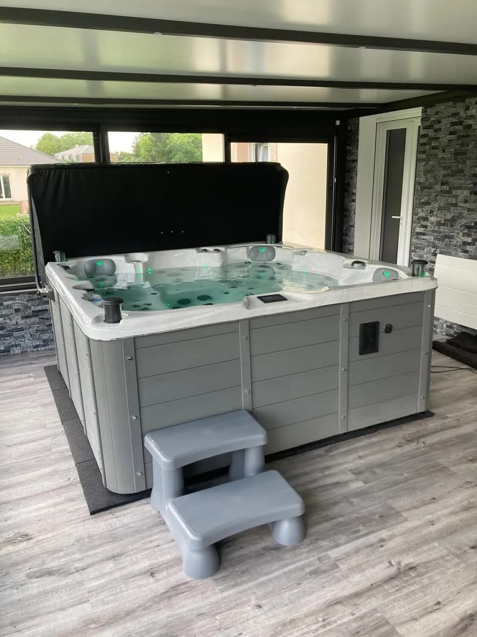 Installation d'un spa Vancouver Full option à Amagne, sous une pergola, avec marchepied