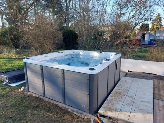 Installation d'un spa Vancouver Full option au Luxembourg, sur une terrasse au bord d'un jardin arboré