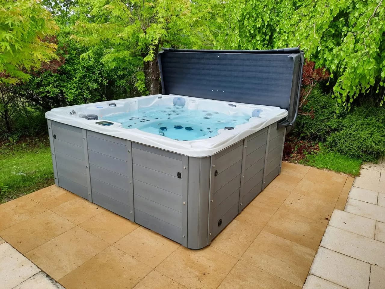 Installation d'un spa Vancouver Full option à Bourguignon, sur une terrasse dallée entourée de végétation