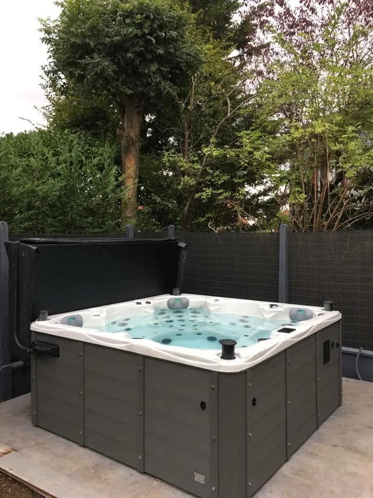 Installation d'un spa Vancouver Full option à Champigny-sur-Marne, sur une dalle devant une palissade