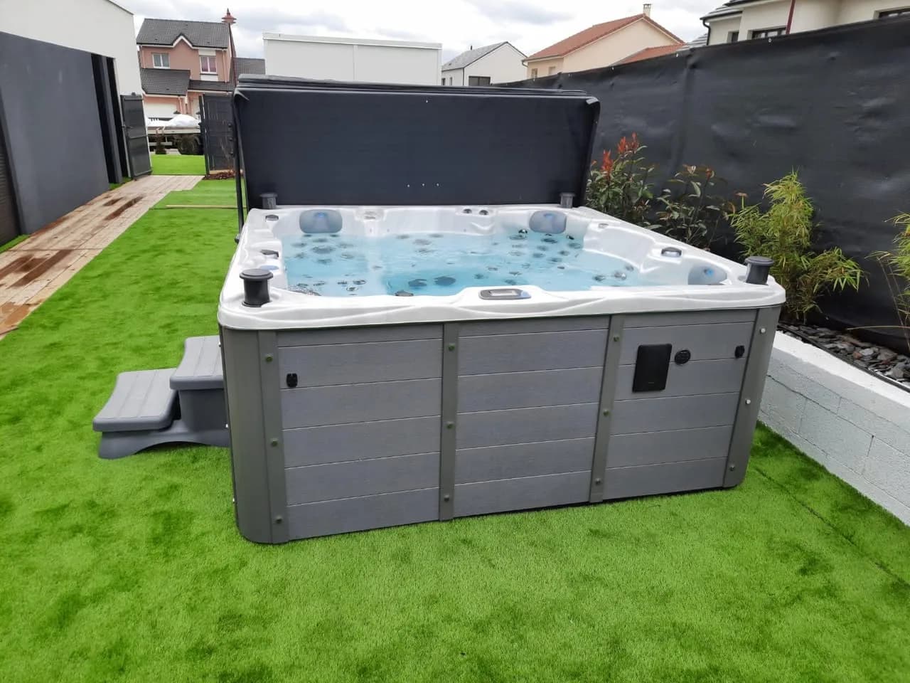 Installation d'un spa Vancouver Full option à Chieulles, sur un gazon synthétique, lève-couverture