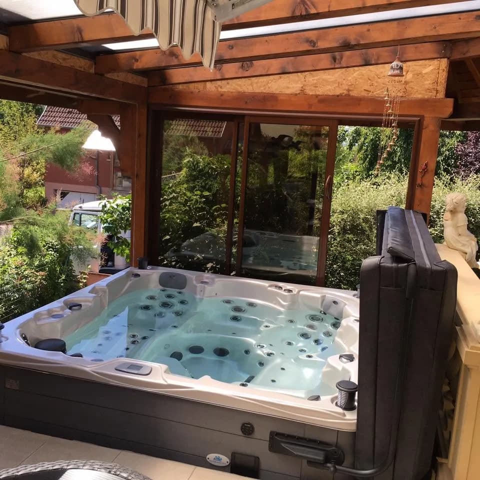 Installation d'un spa Vancouver Full option à Dambach-la-Ville, sous une pergola en bois, lève-couverture